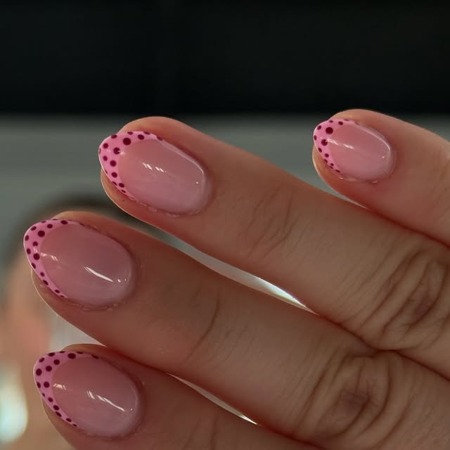 Pink French gel nails with maroon polka-dot tips